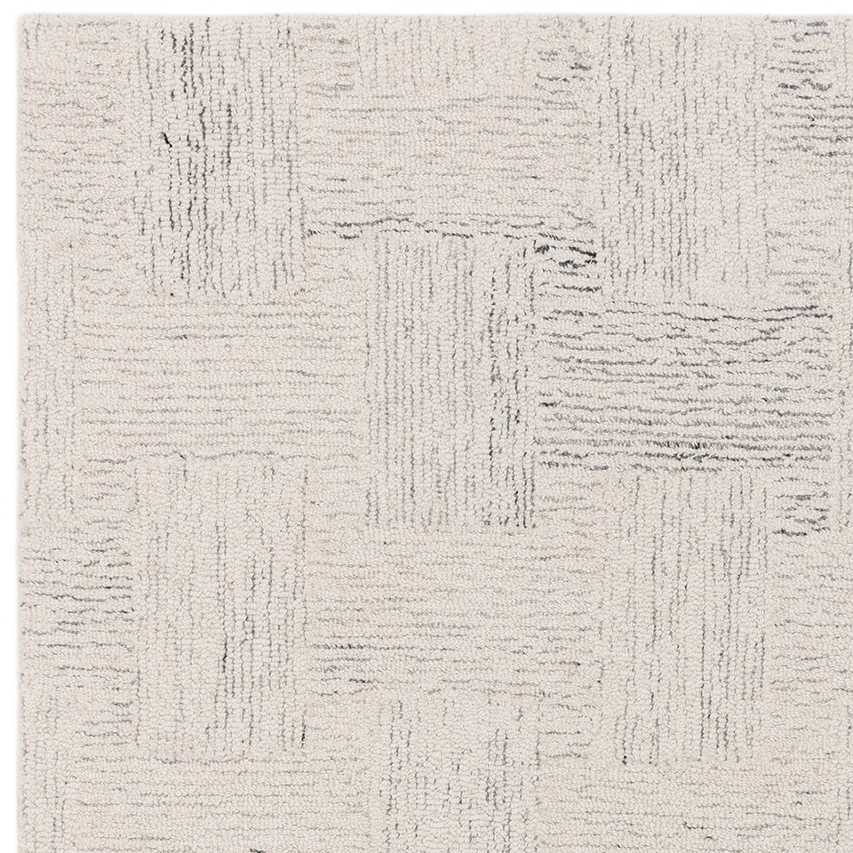 Studio top-down shot focusing on the crisp geometric corner design and bold black lines of a white wool area rug.