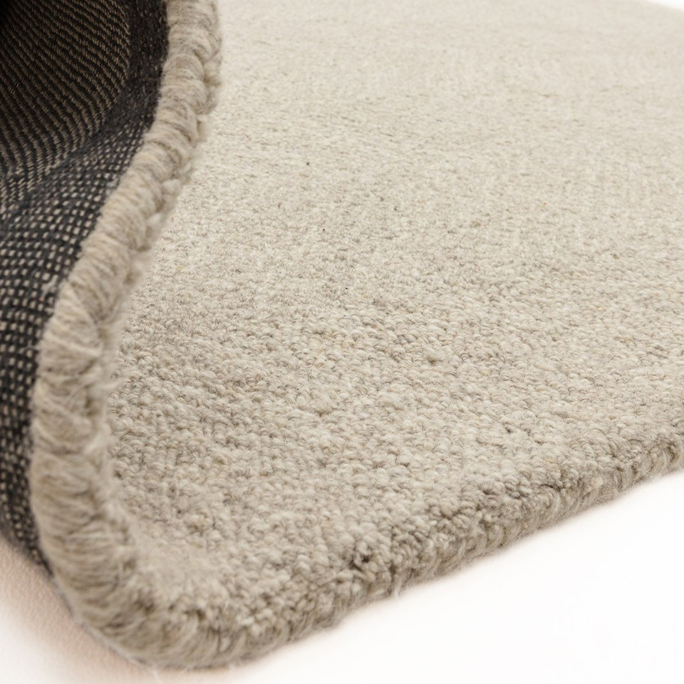 Flipped corner of the Theodore Chevron sand wool rug, displaying its heavy canvas backing and plush, thick texture.