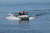 Achilles HB-335AX rigid hull inflatable boat with outboard and passengers.