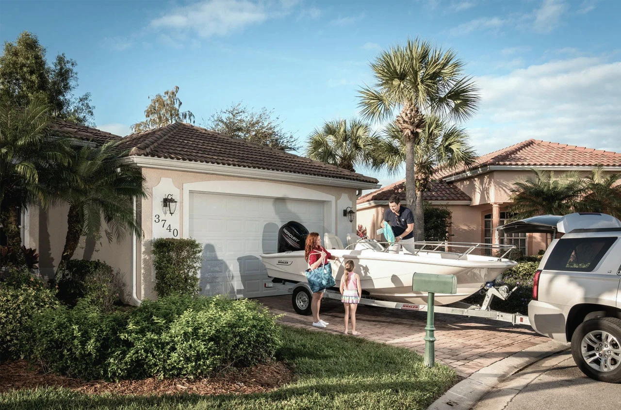 Boston Whaler parked in front of a house.
