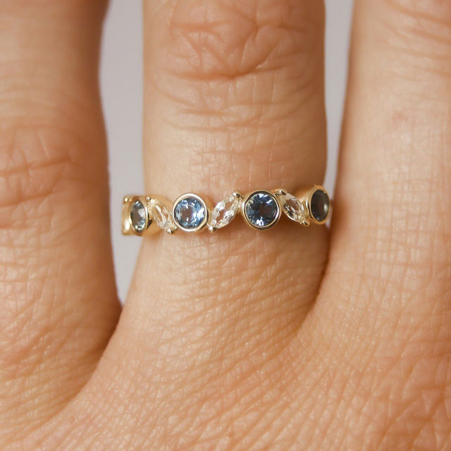 10K yellow gold stacking ring with alternating bezel set round blue topaz and marquise shaped white topaz