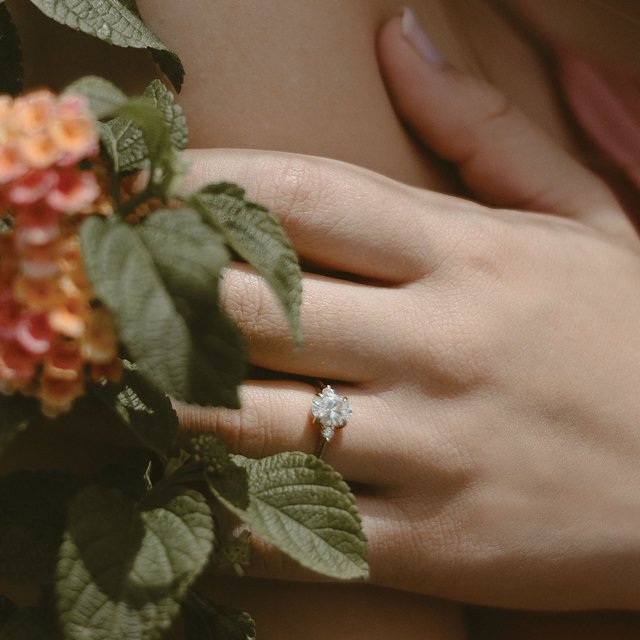 14K gold three stone engagement ring with round acccent diamonds and a polished band with matching wedding ring