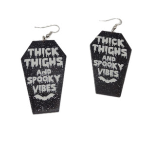 High-quality product images showcasing a pair of bold, gothic-inspired acrylic dangle earrings with a dark, edgy design, captured to highlight detail, size, and overall aesthetic against clean or styled backgrounds.