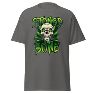 Charcoal gray unisex tee featuring a neon green “Stoned to the Bone” skull design with cannabis leaf eyes and grunge-style lettering, centered on the chest.