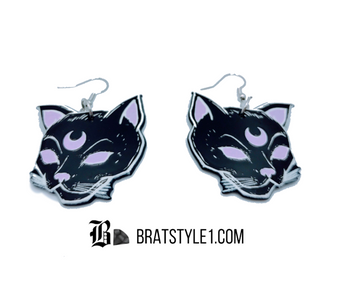 Introducing our enchanting Luna Cat Earrings, a must-have accessory. These earrings beautifully capture the essence of the mystical mentor Luna cat, featuring a captivating image of Luna with the upturned crescent moon symbol adorning its forehead.

The upturned crescent moon symbol on Luna's forehead adds an extra layer of mysticism and enchantment. Representing intuition and inner guidance, the crescent moon symbolizes the wisdom and mentorship that Luna the cat embodies. This powerful symbol serves as a reminder to trust your instincts and embrace the divine guidance that surrounds you.

Embrace your inner mystic and showcase your love for cats with these Luna Cat Earrings. Let Luna's guidance and the power of the crescent moon symbol inspire you to reach for the stars and trust in your own wisdom. Elevate your personal style and enchant those around you with these captivating earrings.