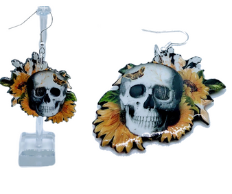 Introducing our unique and captivating Skull Sunflower earrings! These one-of-a-kind earrings are designed to make a bold fashion statement while adding a touch of edgy elegance to any outfit. At the heart of these earrings is a stunning skull, that sits atop a vibrant bouquet of sunflowers, symbolizing resilience and positivity, making these earrings a perfect blend of dark and vibrant elements. To add a whimsical touch, delicate butterflies adorn the forehead of the skull, symbolizing transformation and beauty. The combination of the skull head, sunflowers, and butterflies creates a captivating juxtaposition, representing the cycle of life and the beauty that can arise from darkness. These earrings are made from high-quality acrylic, ensuring durability while maintaining a lightweight feel for comfortable wear throughout the day. The vibrant colors of the sunflowers and butterflies are expertly embedded within the acrylic, ensuring long-lasting vibrancy and avoiding any fading or discoloration over time. Add a touch of intrigue and enchantment to your ensemble with these extraordinary earrings. Introducing our unique and captivating Skull Sunflower earrings! These one-of-a-kind earrings are designed to make a bold fashion statement while adding a touch of edgy elegance to any outfit. At the heart of these earrings is a stunning skull, that sits atop a vibrant bouquet of sunflowers, symbolizing resilience and positivity, making these earrings a perfect blend of dark and vibrant elements. To add a whimsical touch, delicate butterflies adorn the forehead of the skull, symbolizing transformation and beauty. The combination of the skull head, sunflowers, and butterflies creates a captivating juxtaposition, representing the cycle of life and the beauty that can arise from darkness. These earrings are made from high-quality acrylic, ensuring durability while maintaining a lightweight feel for comfortable wear throughout the day. The vibrant colors of the sunflowers and butterflies are expertly embedded within the acrylic, ensuring long-lasting vibrancy and avoiding any fading or discoloration over time. Add a touch of intrigue and enchantment to your ensemble with these extraordinary earrings.