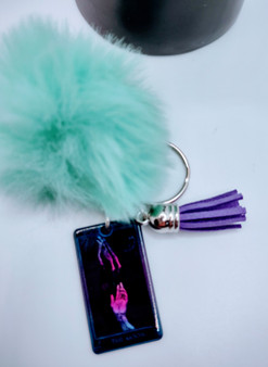 The moon Tarot Card Style Acrylic Keychain is made to celebrate the natural magic of Tarot. The delicate keychain features the moon card. The fur and tassel add an extra bit of detail. Perfect for reminding you that even during tough times, there is still hope. This unique keychain makes the perfect gift for anyone who loves nature! Acrylic Keychain is made with 100% premium acrylic. This keychain makes the perfect gift for all. Our designers carefully choose every material to bring you the best quality and craftsmanship possible. Though the color of the fur may vary upon delivery due to availability, each keychain features an original unique design.