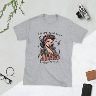 “I Don’t Need Your Attitude I Brought My Own retro pin-up graphic t-shirt featuring vintage rockabilly woman with leather jacket on sport grey shirt, full view showing bold red lettering and edgy statement design.”