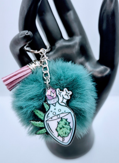 This Green Potion Spell Acrylic Keychain has the extra push of the kush. The green potion bottle depicted on this acrylic keychain throws a magical touch to the vibe. The fur and tassel add an extra bit of detail. This unique keychain makes the perfect gift for anyone! Acrylic Keychain is made with 100% premium acrylic. Our designers carefully choose every material to bring you the best quality and craftsmanship possible. Though the color of the fur may vary upon delivery due to availability, each keychain features an original unique design.