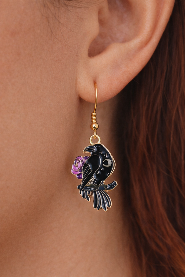 A curated set of Mystic Charm earrings featuring intricate, gothic-inspired designs with enamel detailing and gold-tone hooks. Styled across a mix of clean product shots and moody, aesthetic backgrounds, this collection blends dark elegance with a mystical edge. Each piece showcases unique character and craftsmanship, perfect for adding a bold, alternative statement to any look.