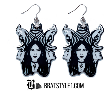 A curated collection of witchy-inspired acrylic earrings featuring dark, mystical designs including celestial symbols, occult figures, crystal shapes, and gothic motifs. Each pair showcases bold black detailing paired with soft lavender accents, displayed in styled scenes with crystals, candles, and moody textures. The collection blends alternative fashion with mystical aesthetics, creating a cohesive, edgy yet feminine visual