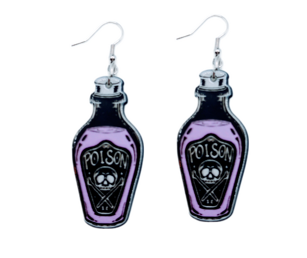 A curated collection of witchy-inspired acrylic earrings featuring dark, mystical designs including celestial symbols, occult figures, crystal shapes, and gothic motifs. Each pair showcases bold black detailing paired with soft lavender accents, displayed in styled scenes with crystals, candles, and moody textures. The collection blends alternative fashion with mystical aesthetics, creating a cohesive, edgy yet feminine visual