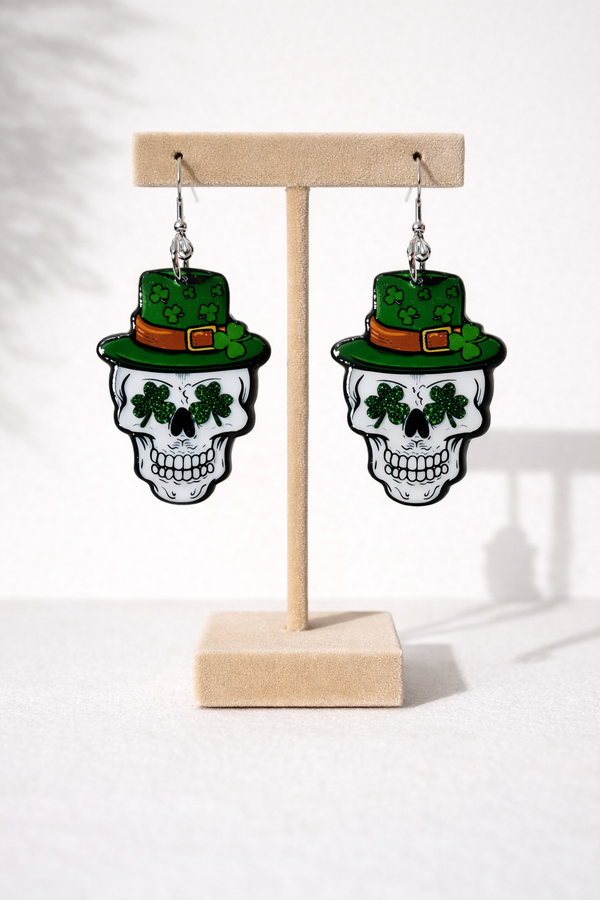 An assorted collection of St. Patrick’s Day-themed acrylic earrings featuring bold, edgy designs with skeletons, skulls, shamrocks, and leprechaun-inspired elements. Each pair showcases vibrant green accents paired with black and white detailing for a high-contrast, gothic-meets-festive aesthetic. Designs include skeleton hands, skull faces, clover details, and playful drinking motifs, all hanging from silver fishhook ear wires. This set blends dark humor, alternative style, and holiday spirit for a unique, statement-making accessory lineup.