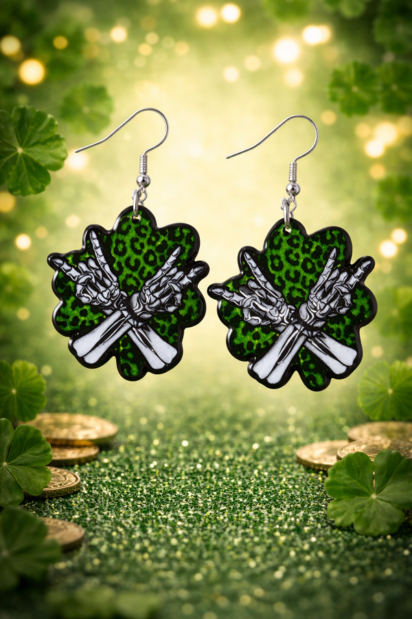 An assorted collection of St. Patrick’s Day-themed acrylic earrings featuring bold, edgy designs with skeletons, skulls, shamrocks, and leprechaun-inspired elements. Each pair showcases vibrant green accents paired with black and white detailing for a high-contrast, gothic-meets-festive aesthetic. Designs include skeleton hands, skull faces, clover details, and playful drinking motifs, all hanging from silver fishhook ear wires. This set blends dark humor, alternative style, and holiday spirit for a unique, statement-making accessory lineup.