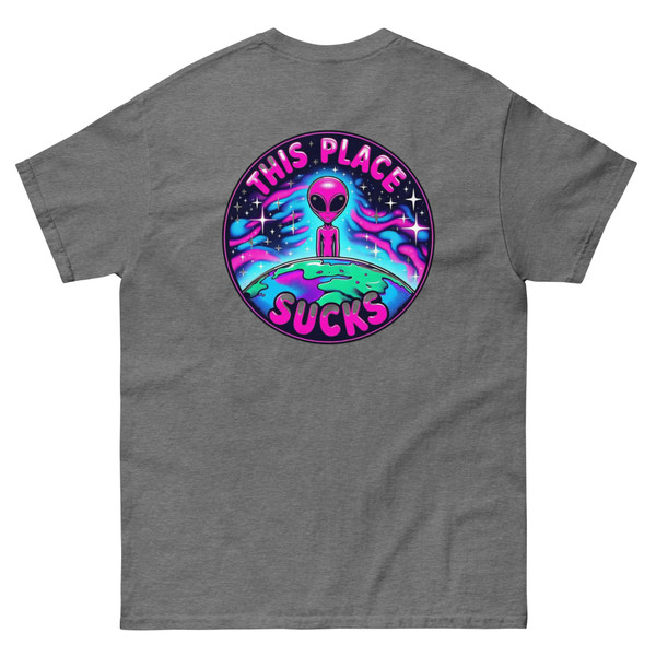 Unisex t-shirt displayed flat showing a bright alien graphic printed small on the front pocket and large on the back. Neon-style, colorful design with bold “This Place Sucks” lettering.