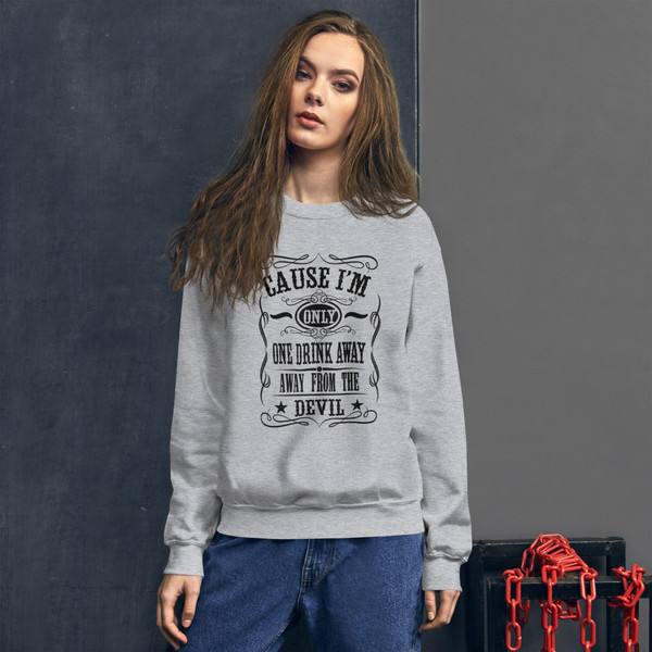 “One Drink Away From The Devil western humor crewneck sweatshirt featuring bold country-style typography, full view showing statement graphic design, perfect for country music lovers and outlaw-inspired fashion.”
