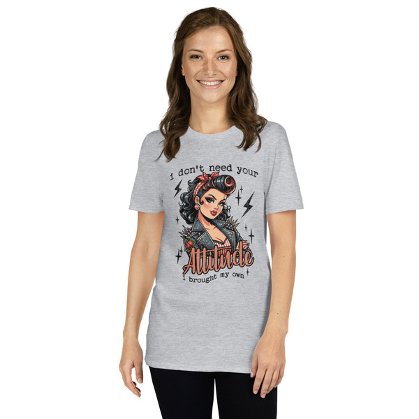 “I Don’t Need Your Attitude I Brought My Own retro pin-up graphic t-shirt featuring vintage rockabilly woman with leather jacket on sport grey shirt, full view showing bold red lettering and edgy statement design.”