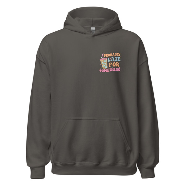 Charcoal gray pullover hoodie with a small left chest graphic featuring a pastel iced coffee and retro lettering that reads “Probably Late For Something.” The hoodie has a kangaroo pocket and relaxed fit.