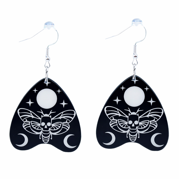 Collection of Ouija planchette acrylic earrings displayed in multiple design variations on a clean background. Each pair features unique lettering styles, symbols, and finishes while maintaining a cohesive dark, witchy aesthetic. The assortment highlights different options within the same occult-inspired theme.