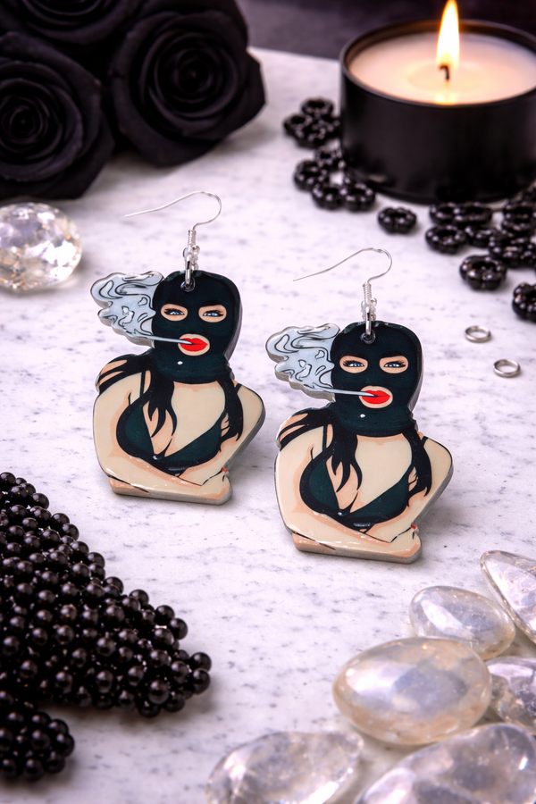 An assortment of edgy acrylic earrings featuring bold, rebellious designs including skeleton hands, sarcastic symbols, and attitude-driven graphics. Each pair showcases high-contrast detailing and expressive themes, styled against clean or minimal backgrounds to highlight their statement-making appeal.