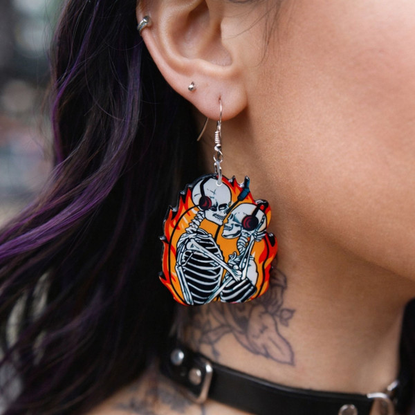 High-quality product images showcasing a pair of bold, gothic-inspired acrylic dangle earrings with a dark, edgy design, captured to highlight detail, size, and overall aesthetic against clean or styled backgrounds.