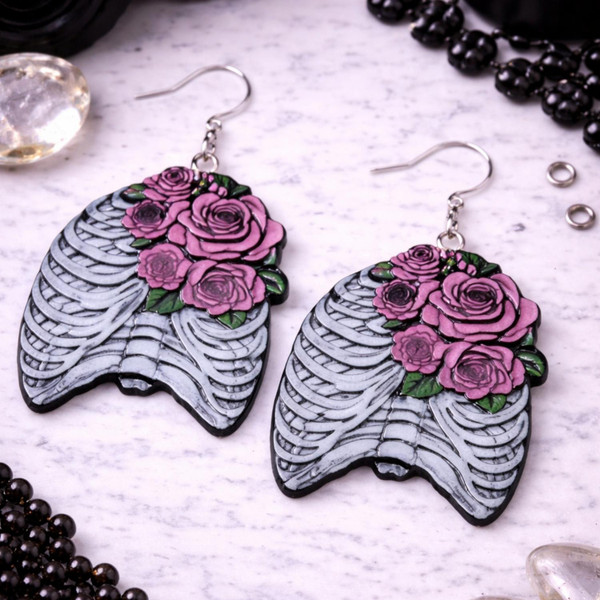 High-quality product images showcasing a pair of bold, gothic-inspired acrylic dangle earrings with a dark, edgy design, captured to highlight detail, size, and overall aesthetic against clean or styled backgrounds.