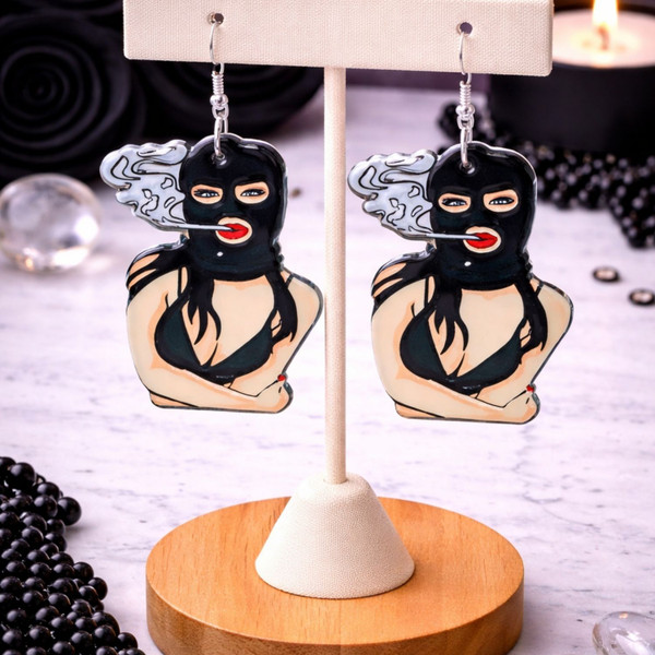 High-quality product images showcasing a pair of bold, gothic-inspired acrylic dangle earrings with a dark, edgy design, captured to highlight detail, size, and overall aesthetic against clean or styled backgrounds.
