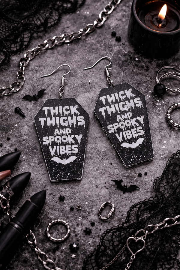 High-quality product images showcasing a pair of bold, gothic-inspired acrylic dangle earrings with a dark, edgy design, captured to highlight detail, size, and overall aesthetic against clean or styled backgrounds.