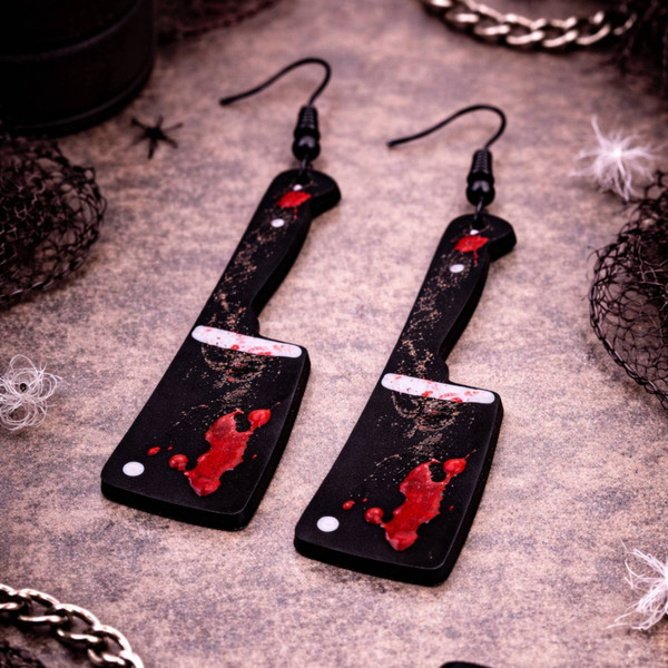 High-quality product images showcasing a pair of bold, gothic-inspired acrylic dangle earrings with a dark, edgy design, captured to highlight detail, size, and overall aesthetic against clean or styled backgrounds.