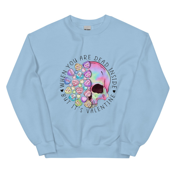 Crew neck sweatshirt shown flat featuring a skull surrounded by pastel Valentine heart candies. Text reads “When You’re Dead Inside” in bold lettering above the skull. Design combines dark humor with playful Valentine colors.