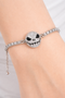 Features a rhinestone skull bracelet showcased across multiple views, including a crisp white background product shot, a clean display stand image for structure and shape, a close-up worn-on-wrist lifestyle photo for scale, and a styled flat lay with dark, gothic-inspired elements to highlight its edgy aesthetic and sparkle.