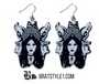 A curated collection of witchy-inspired acrylic earrings featuring dark, mystical designs including celestial symbols, occult figures, crystal shapes, and gothic motifs. Each pair showcases bold black detailing paired with soft lavender accents, displayed in styled scenes with crystals, candles, and moody textures. The collection blends alternative fashion with mystical aesthetics, creating a cohesive, edgy yet feminine visual