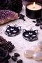 A curated collection of witchy-inspired acrylic earrings featuring dark, mystical designs including celestial symbols, occult figures, crystal shapes, and gothic motifs. Each pair showcases bold black detailing paired with soft lavender accents, displayed in styled scenes with crystals, candles, and moody textures. The collection blends alternative fashion with mystical aesthetics, creating a cohesive, edgy yet feminine visual