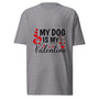Unisex t-shirt shown flat featuring the phrase “My Dog Is My Valentine” with heart graphics. Clean, centered design with a soft Valentine color palette.