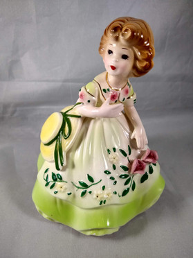 Girl in Green Carrying Hat on Arm