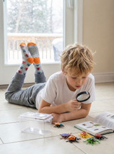 Creepy Crawly Alpaca Kids Grippy Socks, Lifestyle, young boy reading with bug socks on