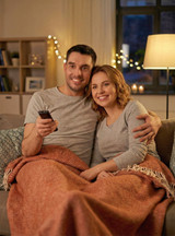 Alpaca Home Monopoly Baby Alpaca Throw Blanket on couple watching TV.