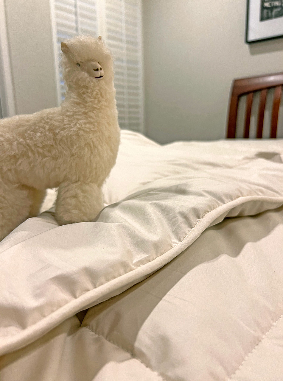 Alpaca Wool Mattress Pad on bed with Alpaca Figure showing thickness and plush.