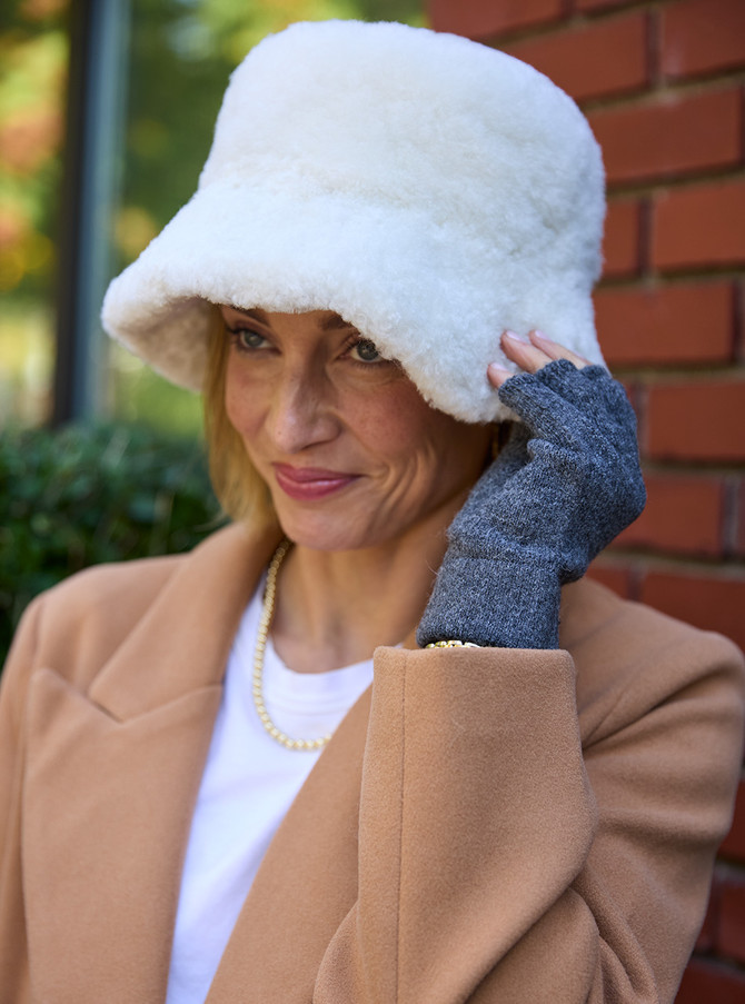Woman wearing fingerless baby alpaca gloves outdoors.