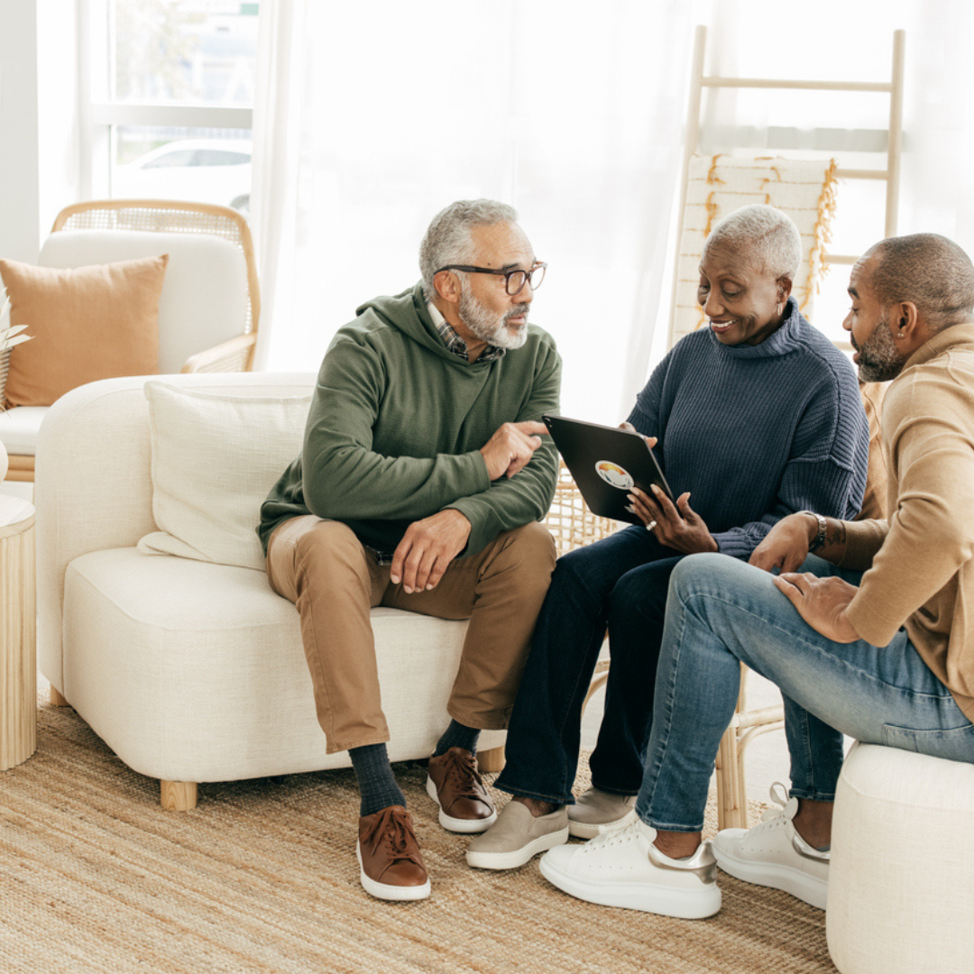 3 adults sitting on a couch discussing health benefits of alpaca clothing