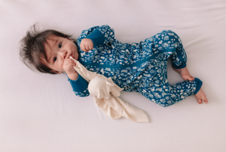 https://cdn11.bigcommerce.com/s-5berkjdmih/images/stencil/385x215/uploaded_images/baby-lying-awake-in-woolbabe-lake-wilderness-pj-suit.png?t=1623382431