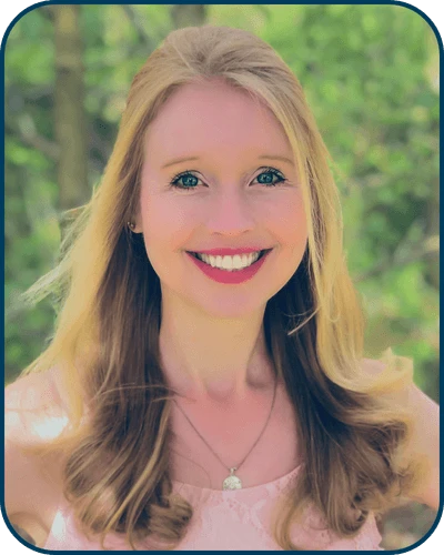 Kat McGrady Headshot: Blonde woman in pink shirt smiling in front of outdoor background