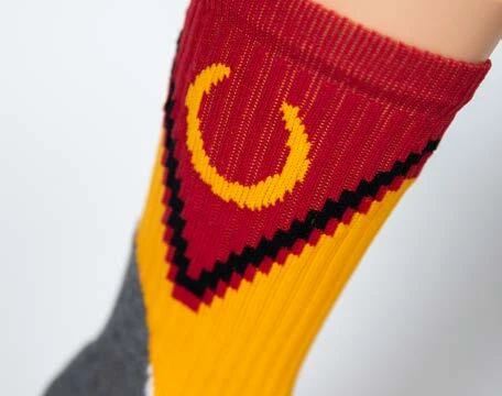 Red yellow and black custom riding sock with a knitted horseshoe motif