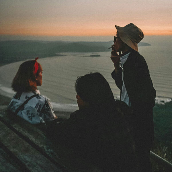 3 people vaping near the coast at sunset