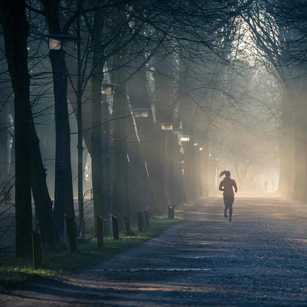 Individual jogging past trees