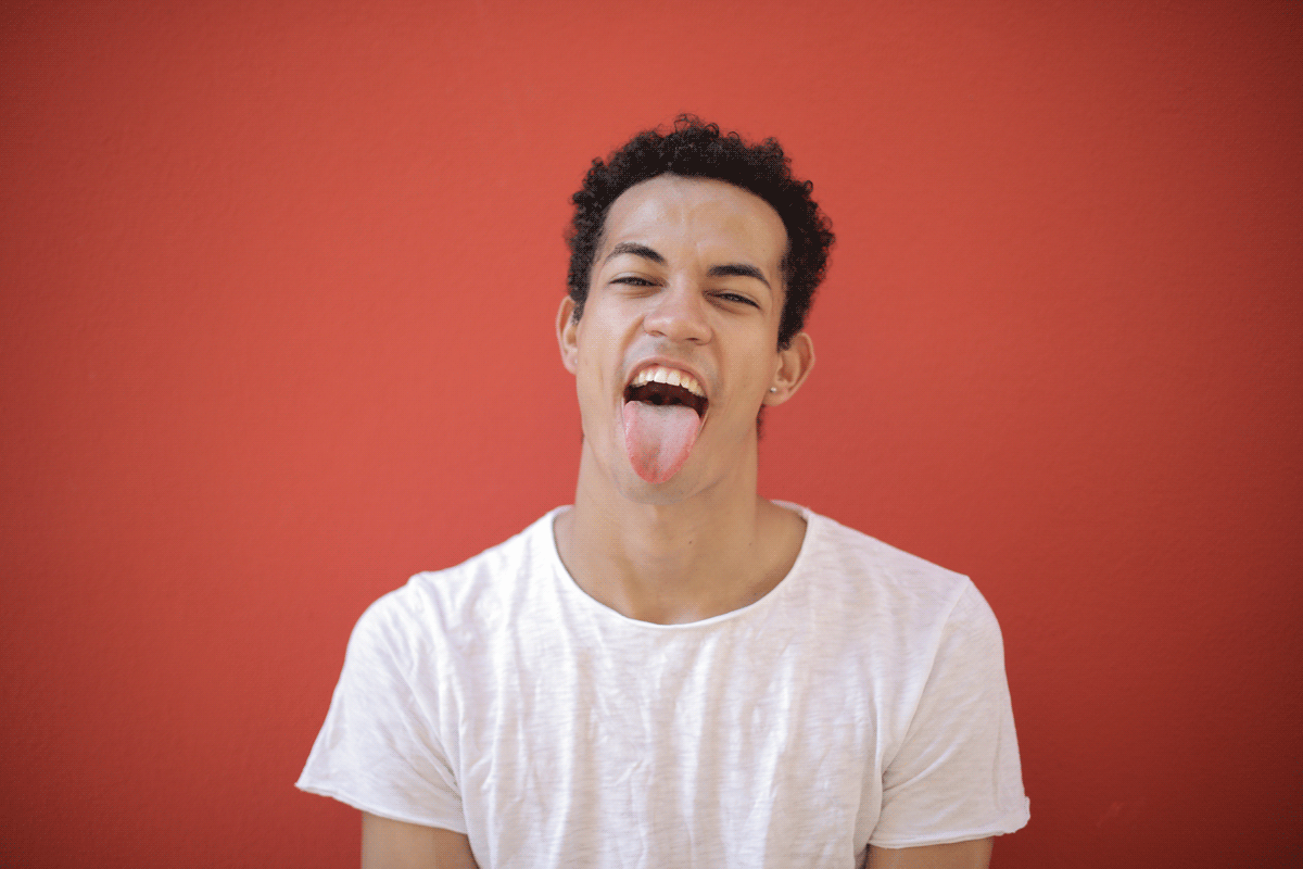 Man with tongue sticking out on red background