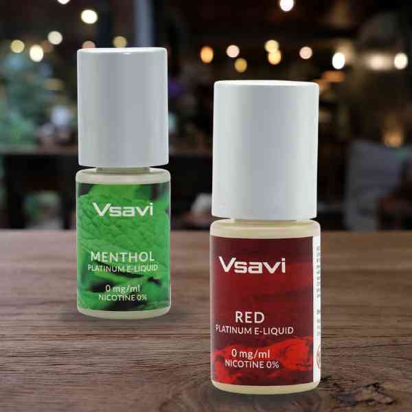 Vsavi Platinum Red and Menthol 0mg bottles standing on a table in an outdoor restaurant during the evening. Vsavi Platinum Red and Menthol bottles