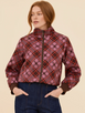 Front view of a model wearing the Renegade Bomber Jacket, showcasing its retro color-blocked panels in deep chocolate, dusty lilac, and red with a front zip closure.