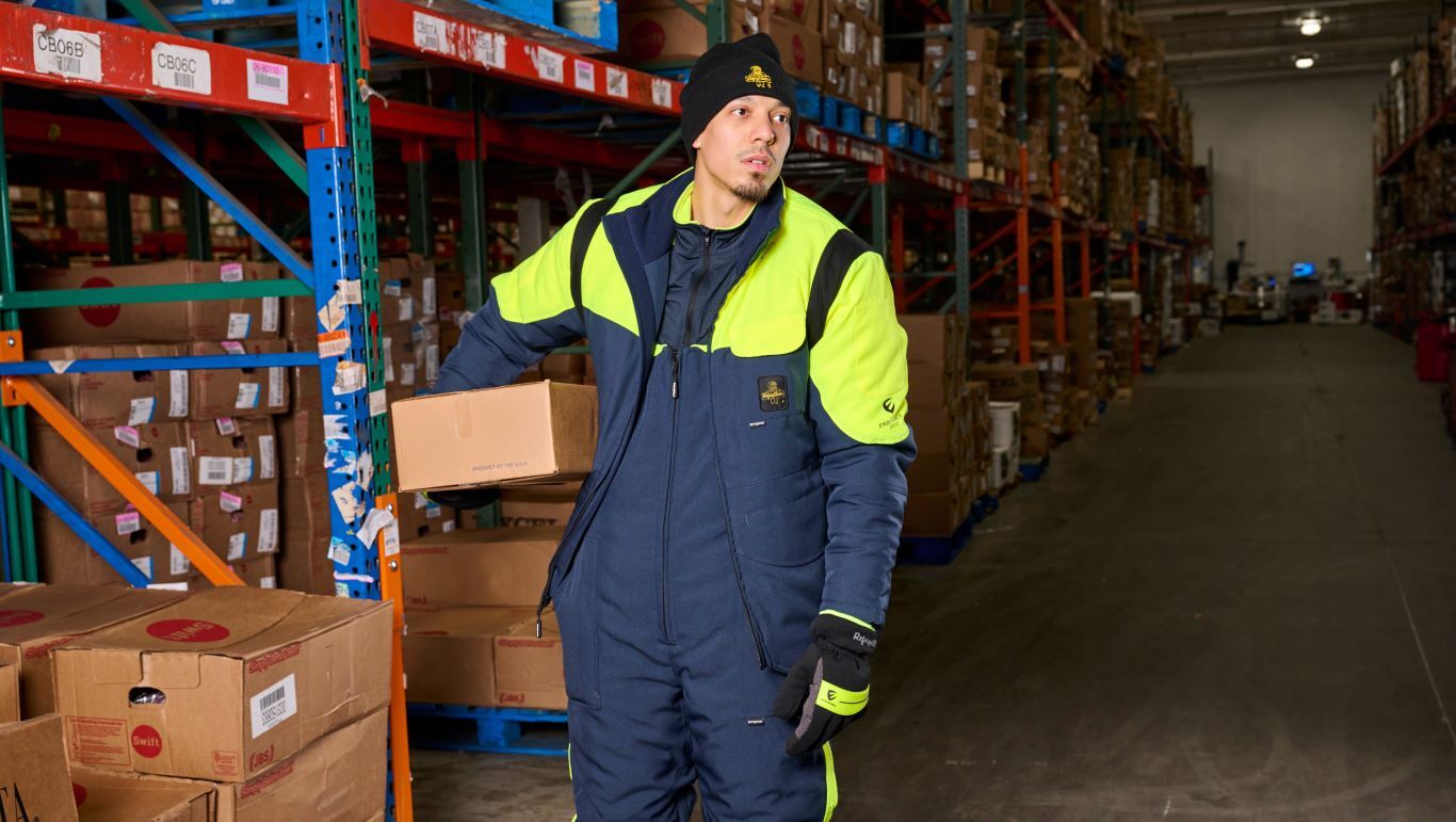 Man wearing high-visibility freezerwear works in a cold storage warehouse.