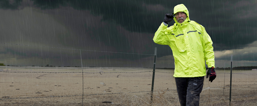 Man working outdoors in heavy-duty rainwear during rainy weather